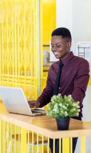 portrait-of-a-young-black-man-using-a-laptop-in-a-working-environment-either-an-african-businessman_t20_onApdA